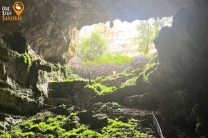 Entrance to Grotta di Su Marmuri: A scenic view of the cave entrance surrounded by lush greenery in the heart of Ulassai, Sardinia.